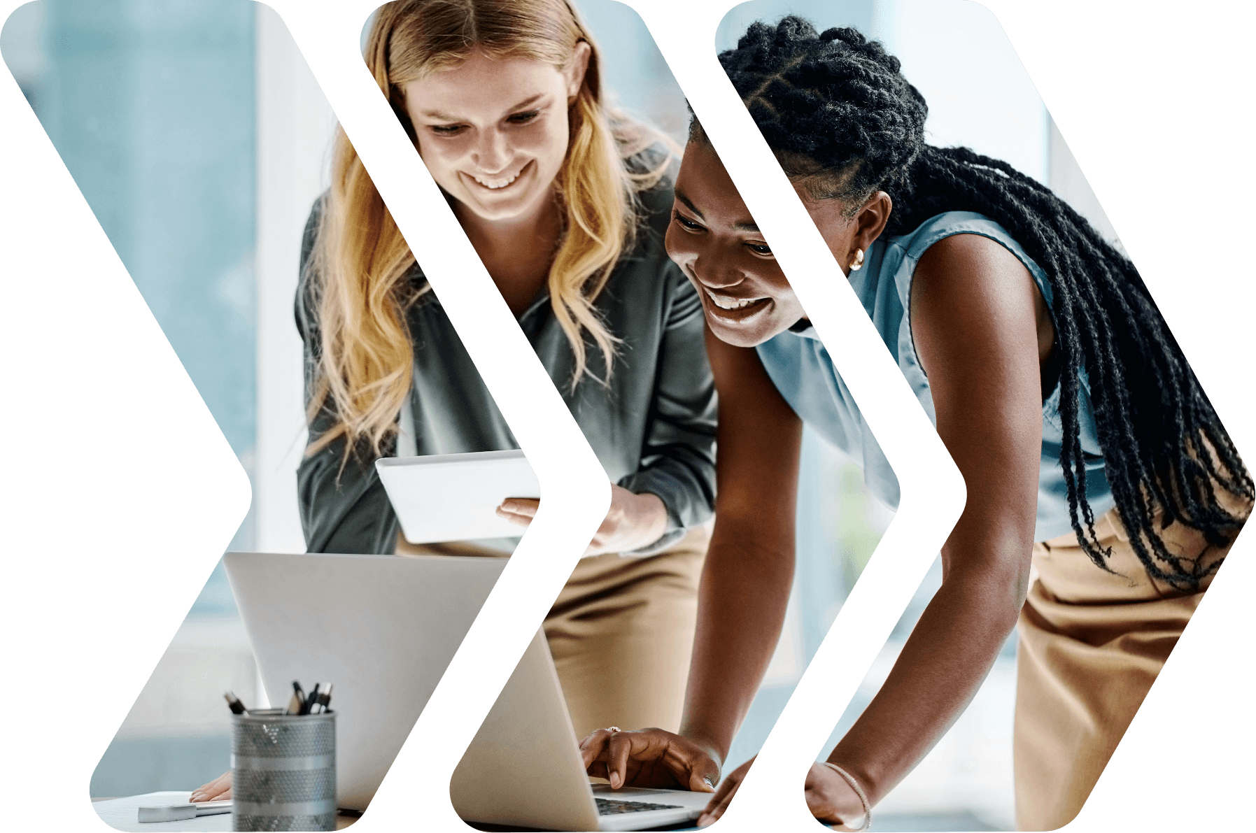 Two co-workers looking at a laptop on a desk.